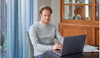 Man doet een zelftest achter zijn laptop