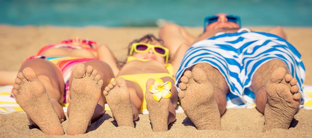Gezin ligt op het strand te zonnen.