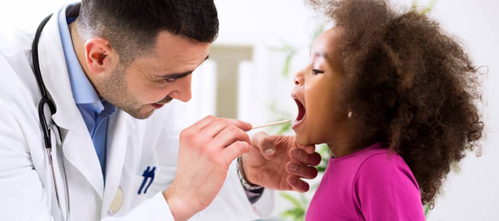 Dokter kijkt in de keel van een klein meisje.