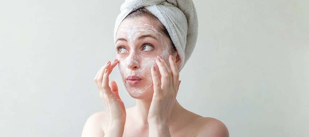 Een vrouw kijkt glimlachend uit het vliegtuigraam