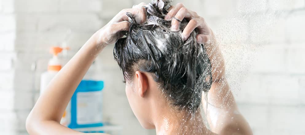 Een vrouw kijkt glimlachend uit het vliegtuigraam