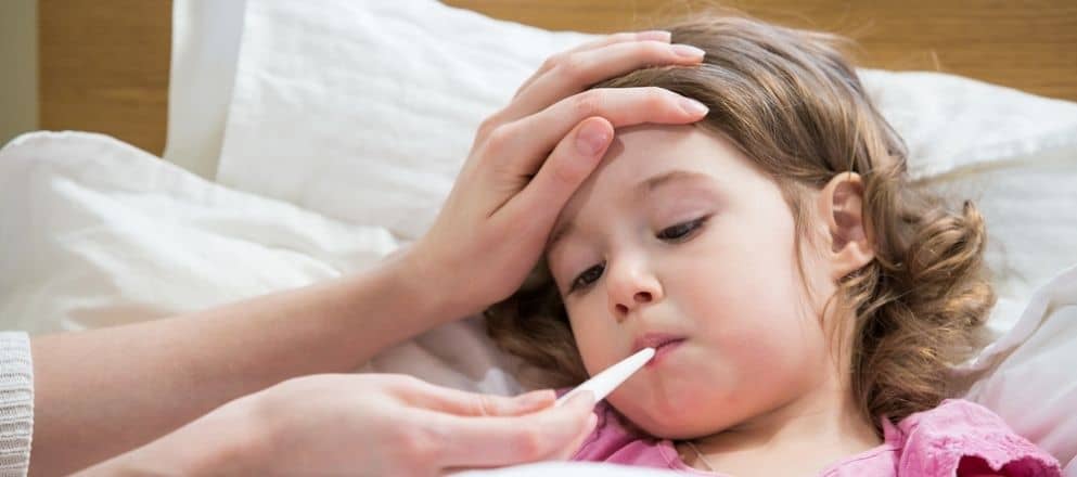 moeder neemt temperatuur op van jongen met griep
